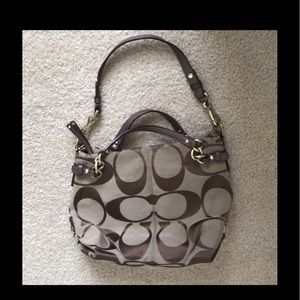 Coach signature handbag with adjustable shoulder strap.